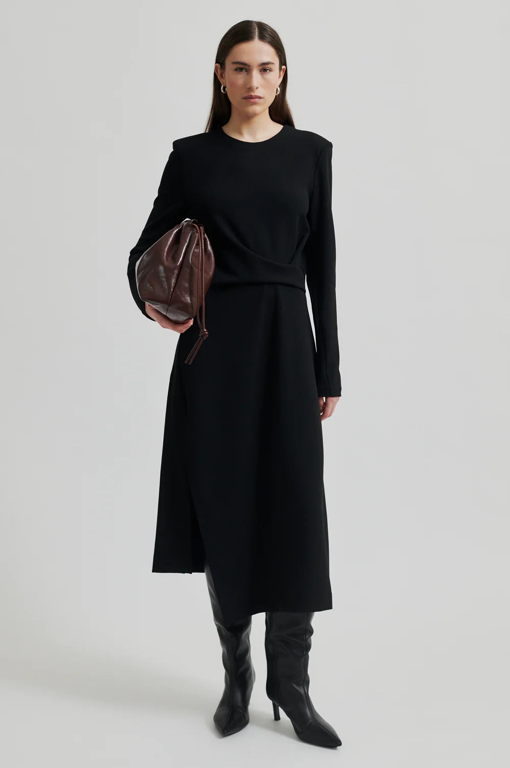 Black long sleeve dress with pleated details at one side that create a flattering draped effect. Front slit. 