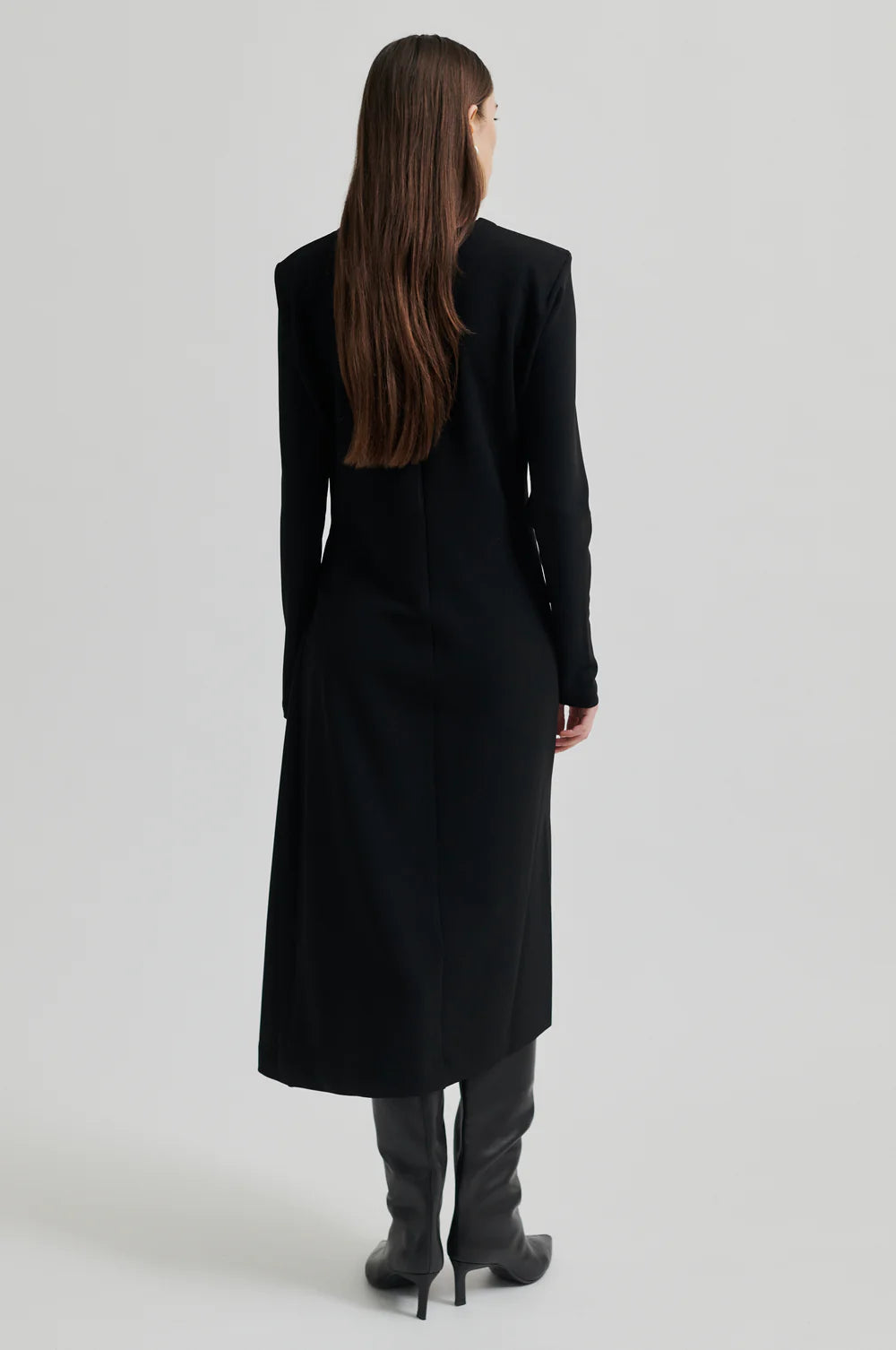 Black long sleeve dress with pleated details at one side that create a flattering draped effect. Front slit. 