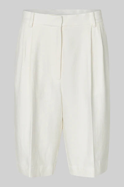 white pleated shorts on a plain background