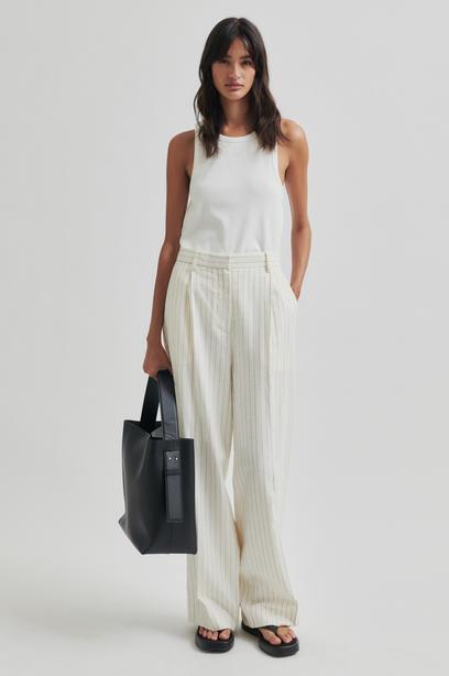 White wide leg pants with thin stripes on a light gray background