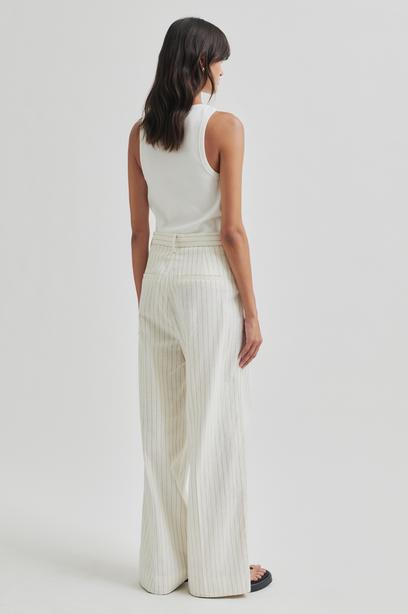 White wide leg pants with thin stripes on a light gray background