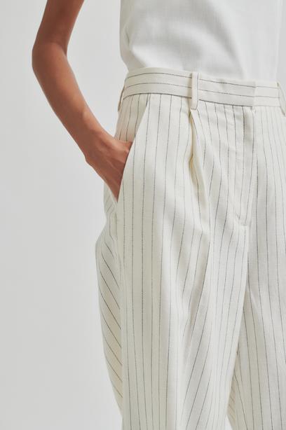 White wide leg pants with thin stripes on a light gray background