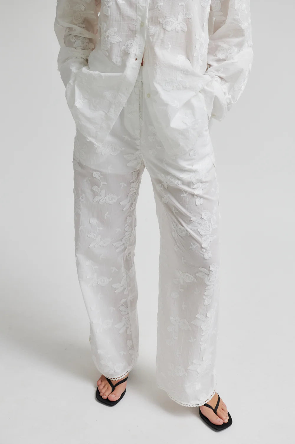 White pants worn by a person on a white background