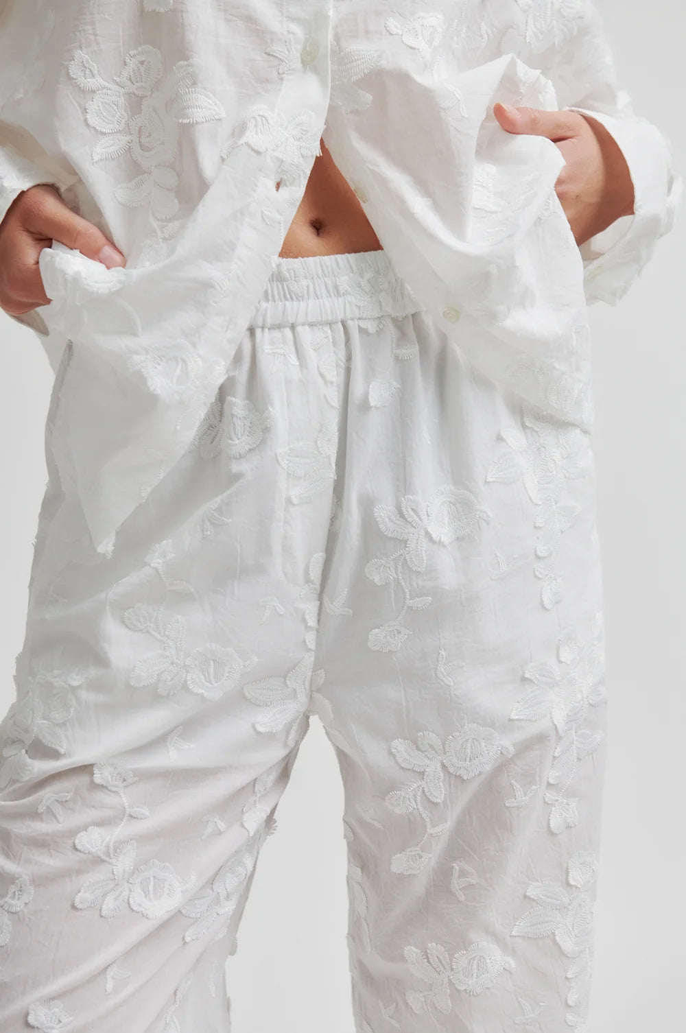 White embroidered outfit with pants and a top on a white background