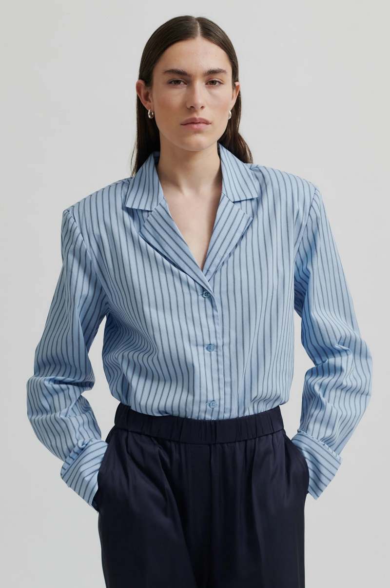 Wide leg mid rise silky pants in navy blue. Wide leg fit with back pockets.
