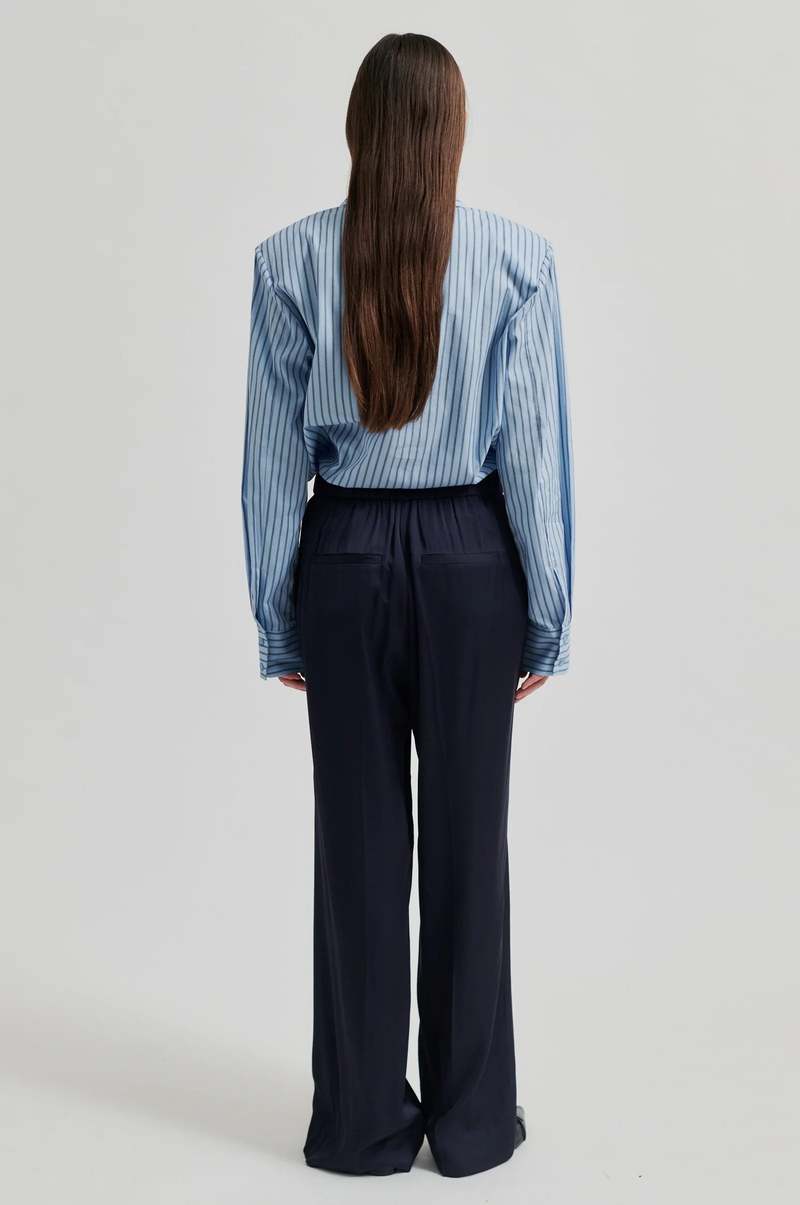 Wide leg mid rise silky pants in navy blue. Wide leg fit with back pockets.