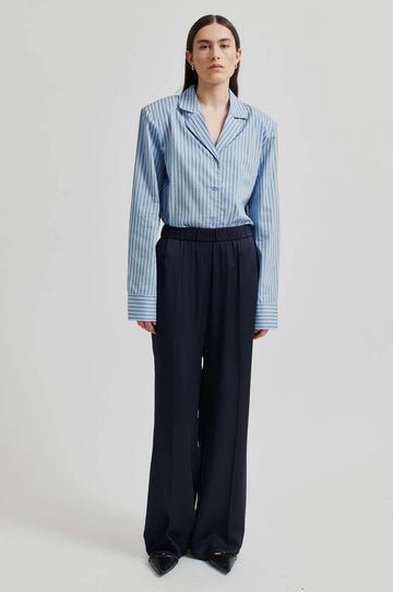Wide leg mid rise silky pants in navy blue. Wide leg fit with back pockets.