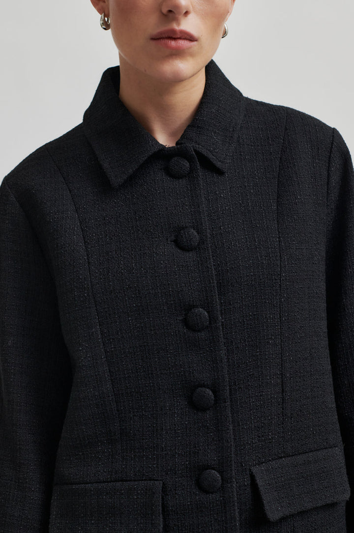 Tailored long sleeve black jacket with shirt collar, front pockets and covered buttons. 