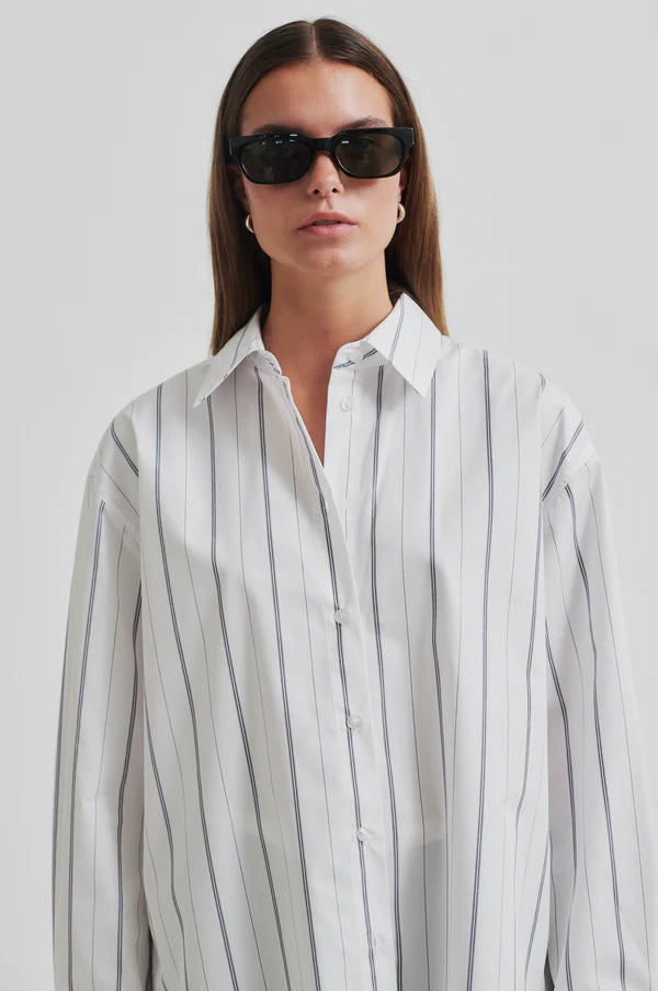 White cotton shirt with black vertical stripes. Long sleeve and oversize fit. 