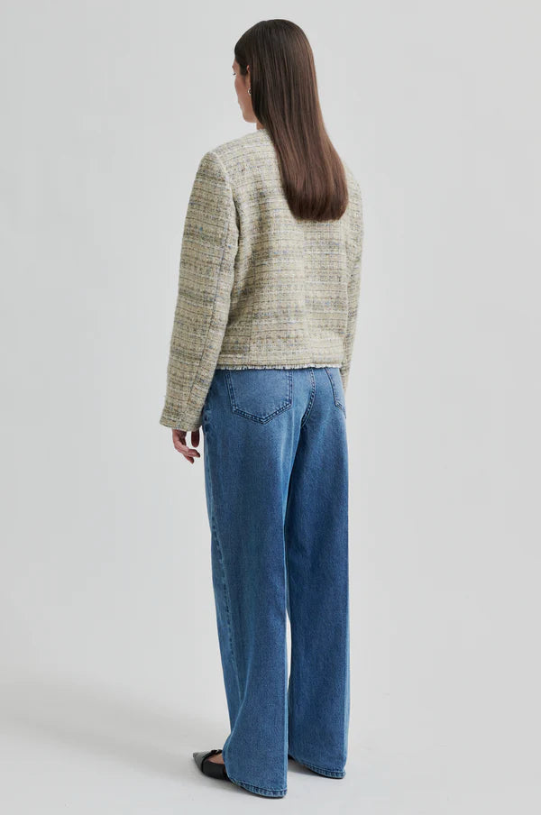 Boxy textured jacket with covered buttons and front pockets. 