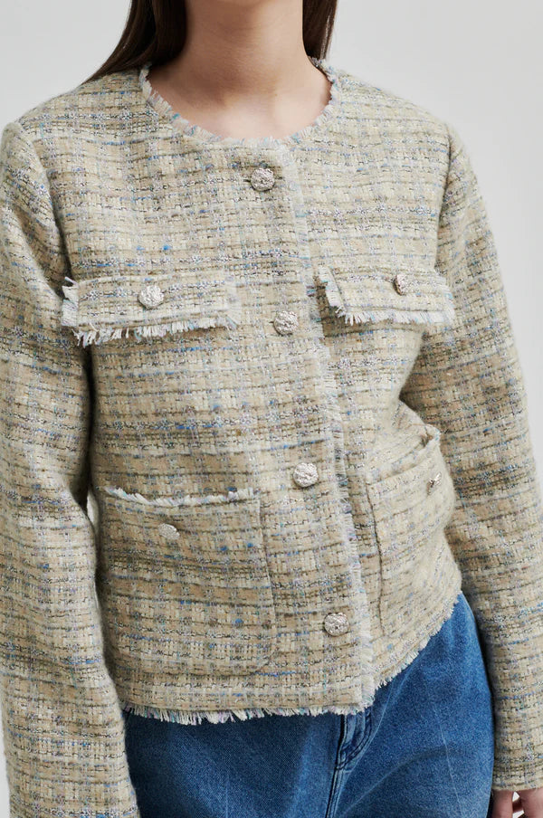 Boxy textured jacket with covered buttons and front pockets. 