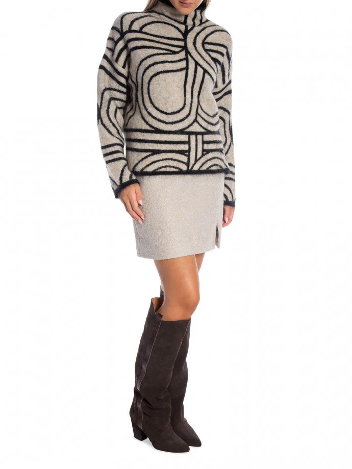 Person wearing a patterned sweater and skirt with knee-high boots on a white background