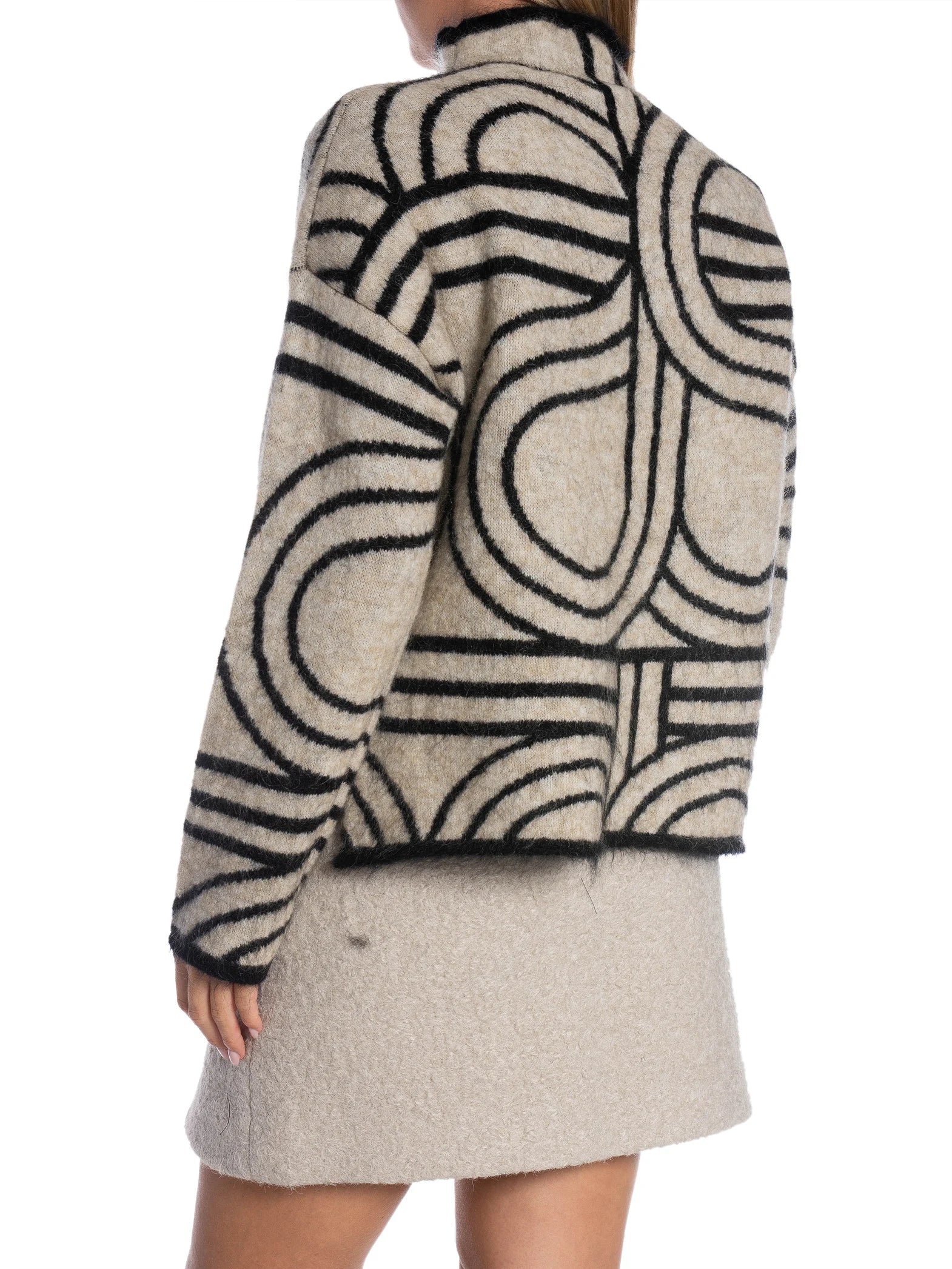 Person wearing a patterned sweater with a plain background