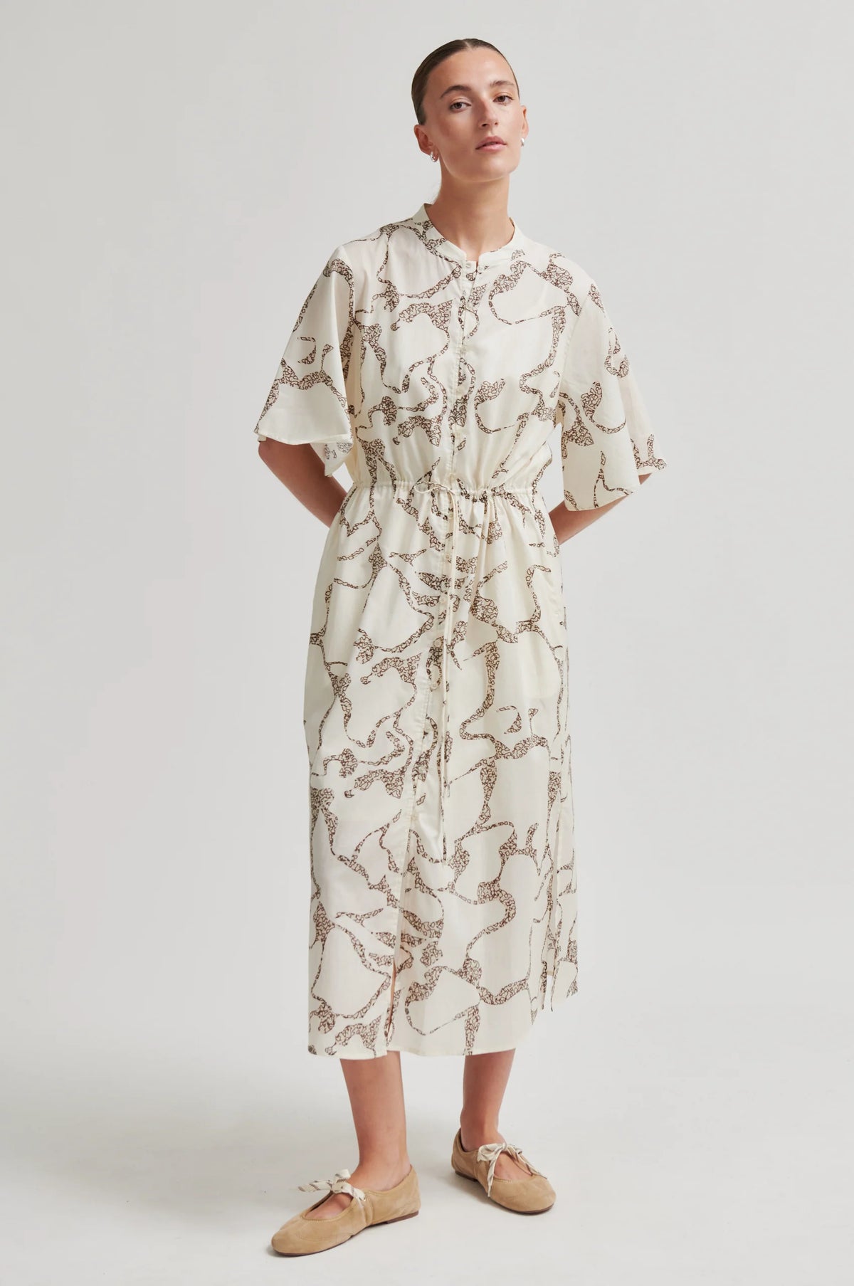 Woman wearing a patterned dress on a white background