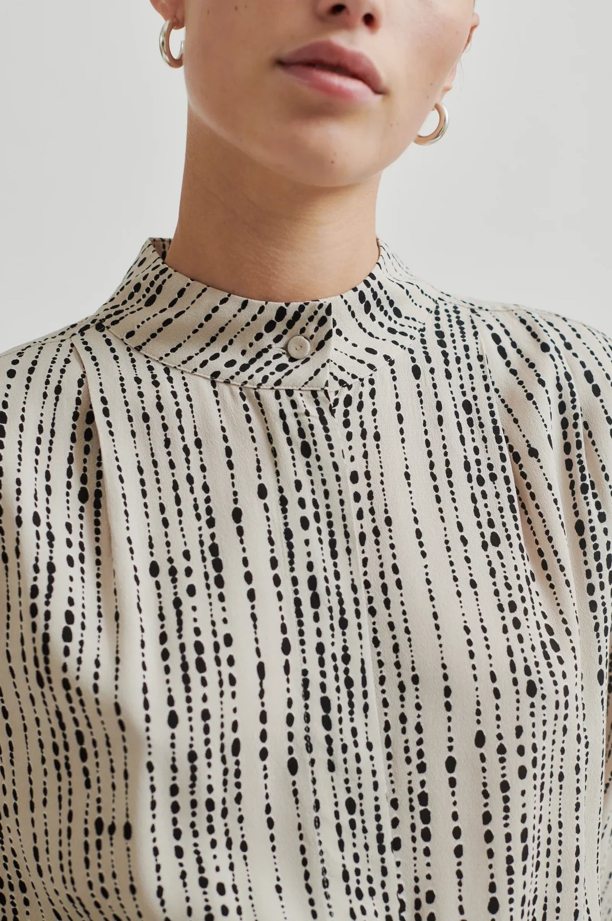 Monochrome shirt with cream base and black print. High neck and long sleeves in a drapy viscose fabric. 