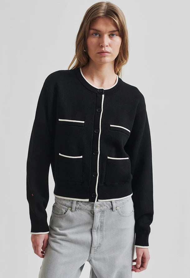Black cardigan with white accents round collar and button through front. 
