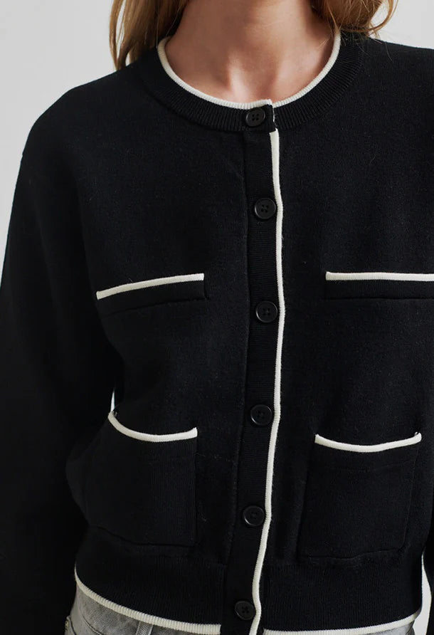 Black cardigan with white accents round collar and button through front. 
