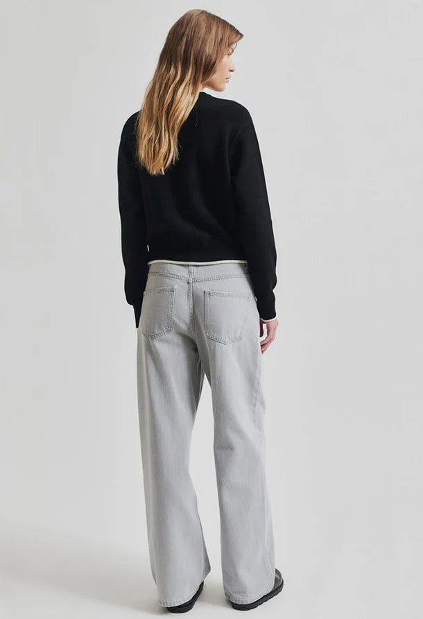 Black cardigan with white accents round collar and button through front. 
