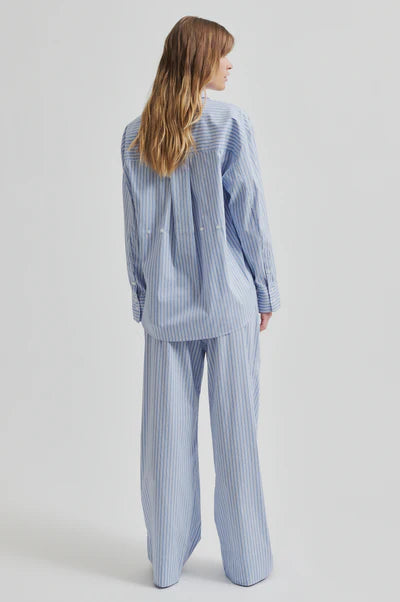 Model wearing a blue and white striped shirt back paired with blue and white striped pants. 