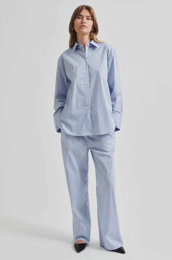 Model wearing a blue and white striped shirt back paired with blue and white striped pants. 