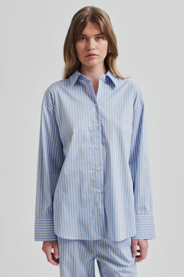 Model wearing a blue and white striped shirt back paired with blue and white striped pants. 