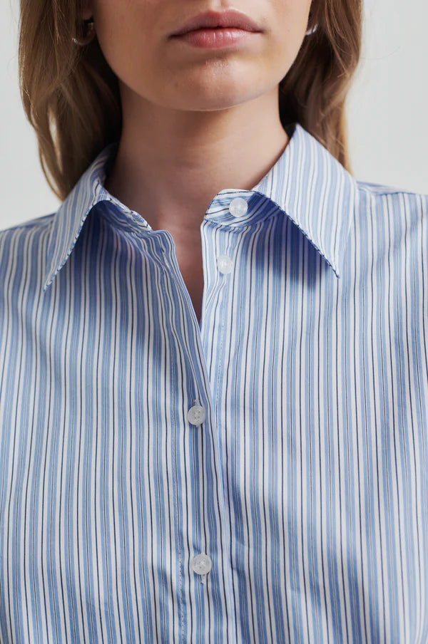 Model wearing a blue and white striped shirt back paired with blue and white striped pants. 