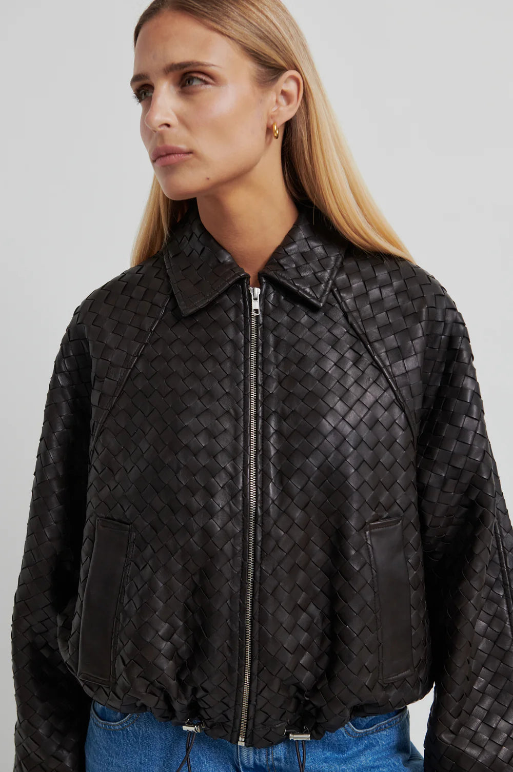 Model wearing a Chocolate Brown woven leather jacket and denim jeans on a light background