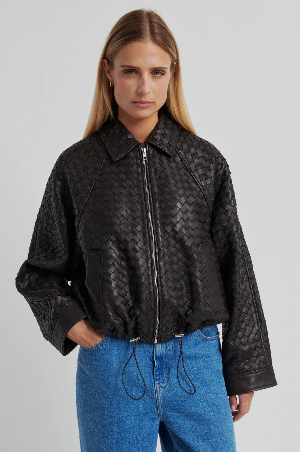 Model wearing a Chocolate Brown woven leather jacket and denim jeans on a light background