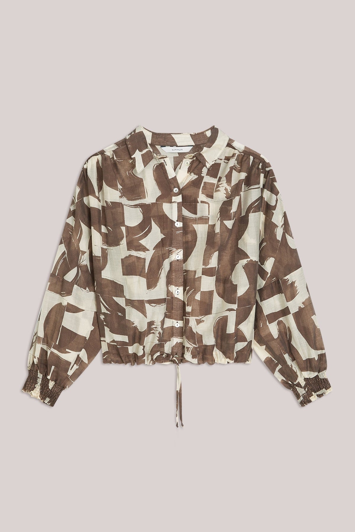 Brown and white patterned womens shirt on a plain background. 