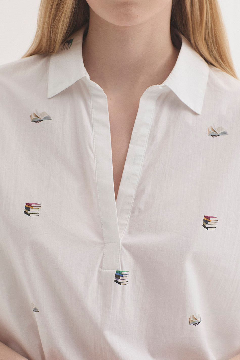 White shirt with book designs on a plain background