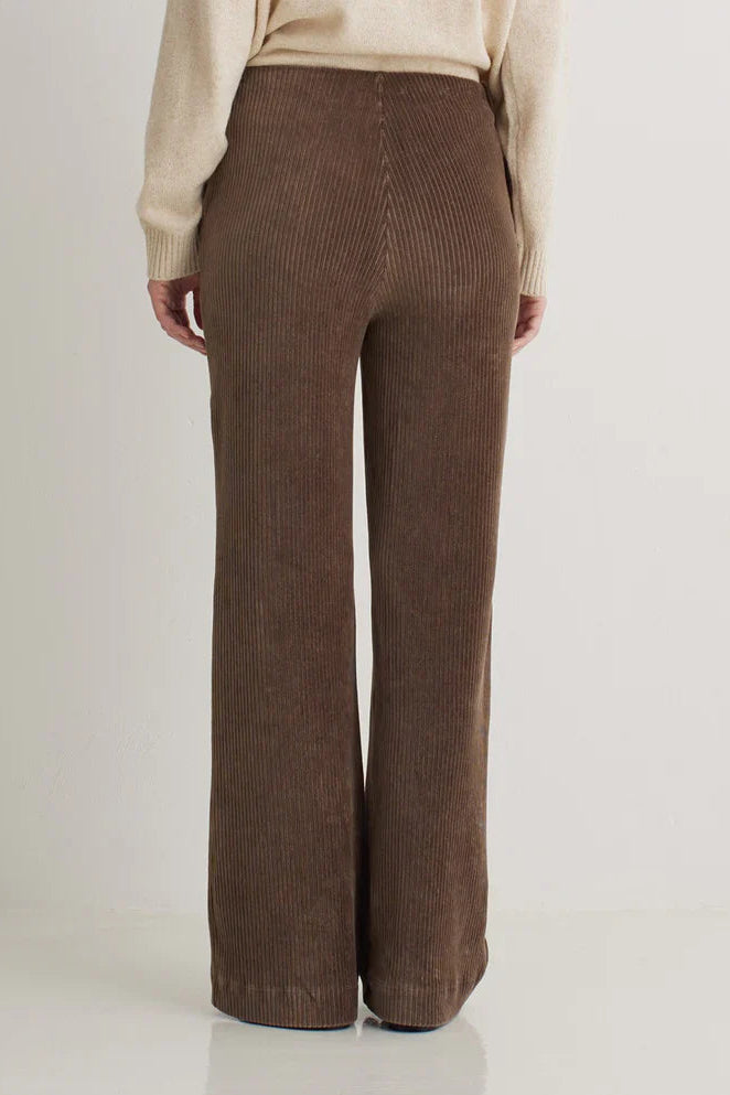 Brown ribbed pants worn by a person on a white background