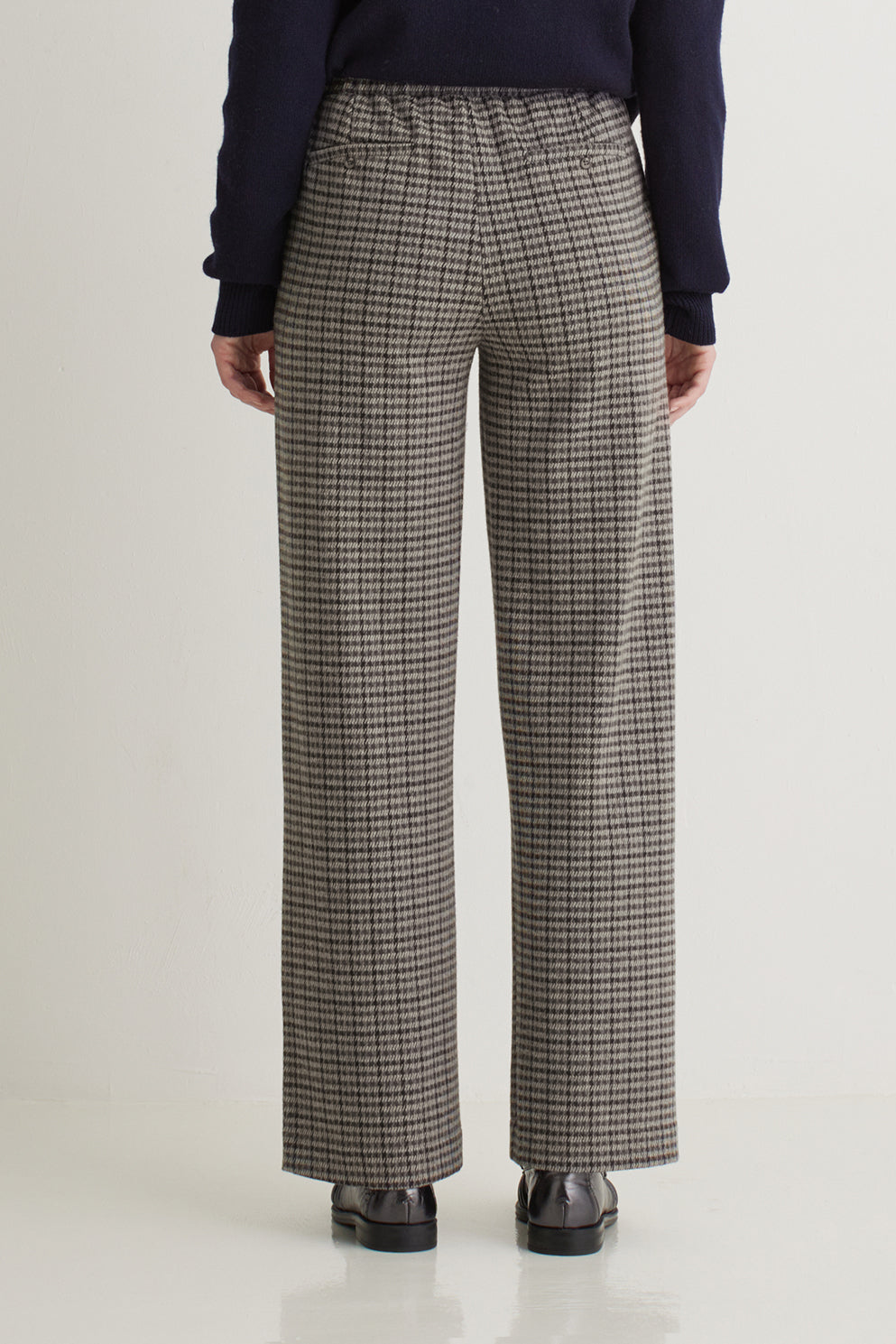 Person wearing plaid pants on a white background