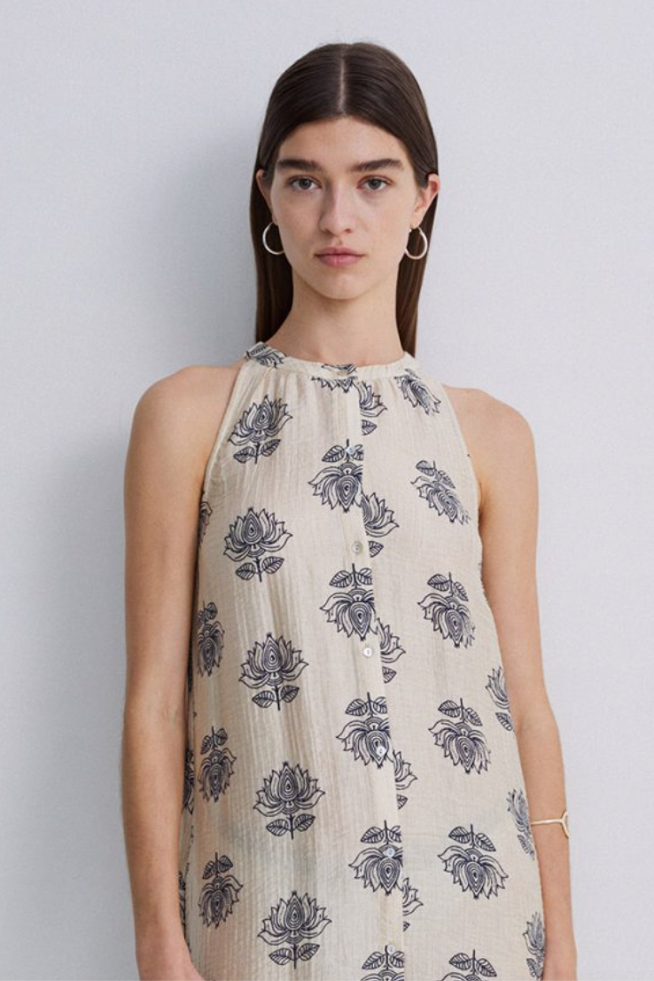 Women wearing a maxi dress with a cream base and blue floral print. 