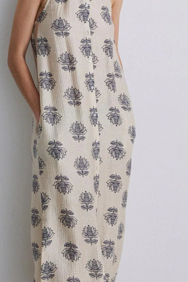 Women wearing a maxi dress with a cream base and blue floral print. 