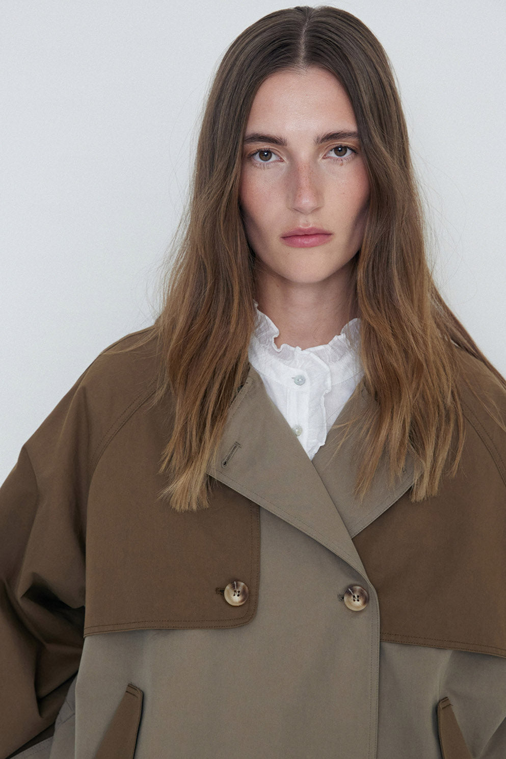 Khaki double breasted two tone short length trench coat  close up 