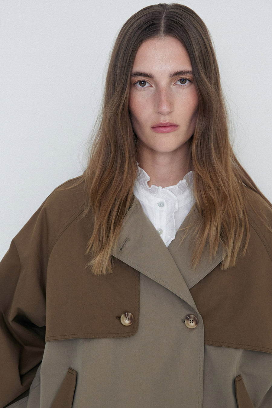 Khaki double breasted two tone short length trench coat  close up 