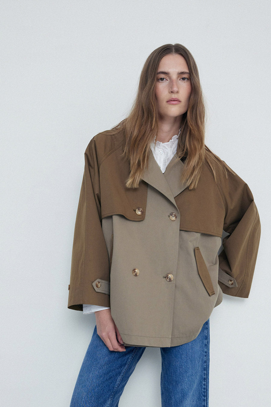 Khaki double breasted short length trench coat  close up. 