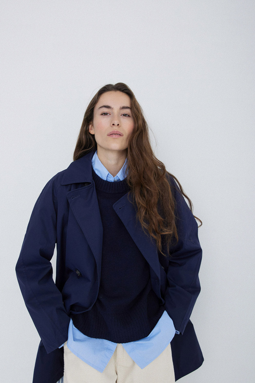 Navy midi length double breasted trench coat with wide belt.  Close up. 