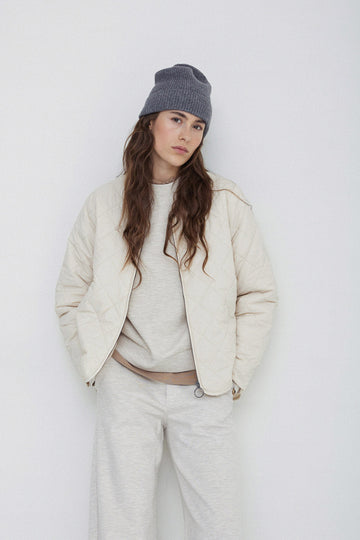 Long sleeve quilted jacket with front zip in natural colour way. 