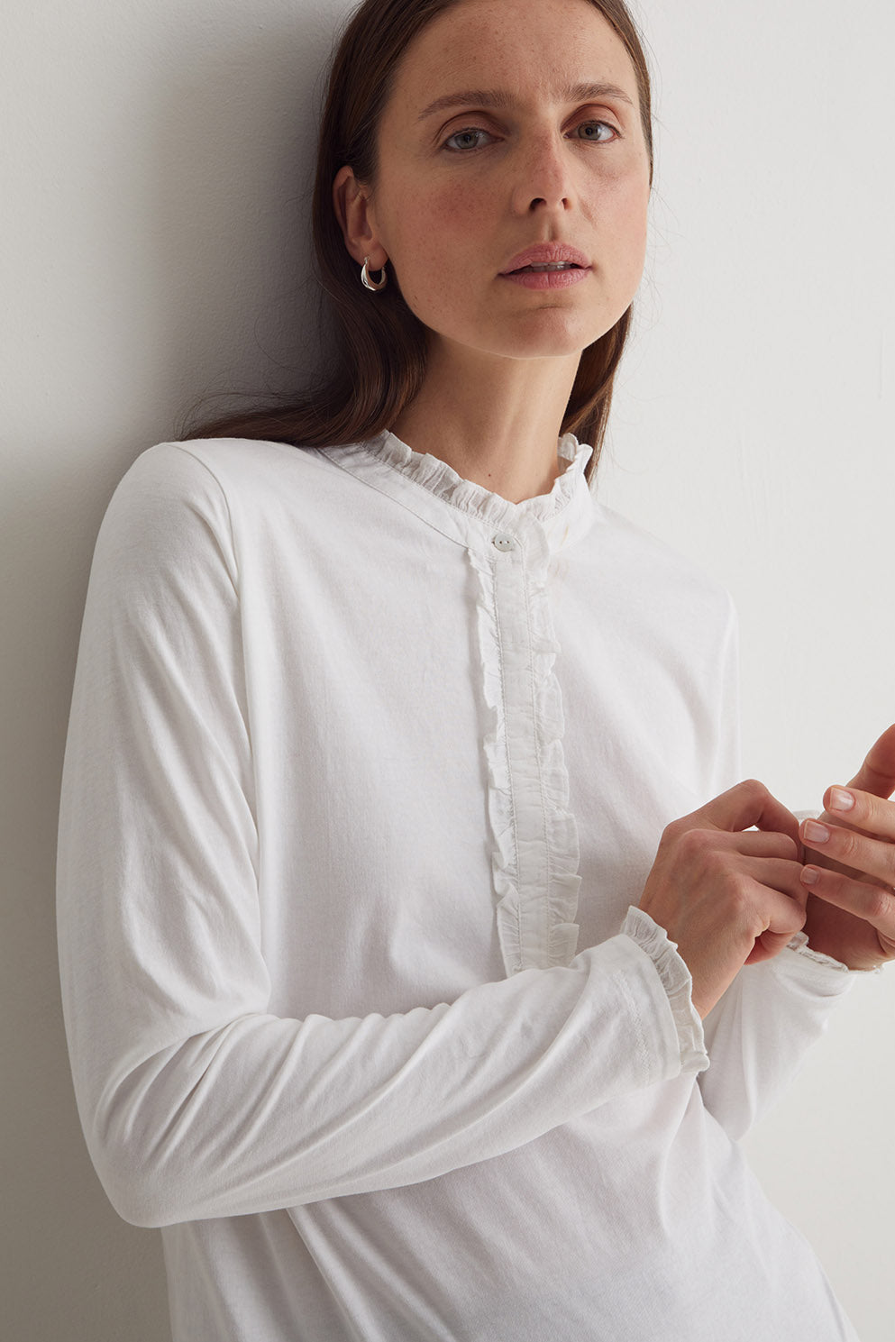 Woman wearing a white blouse against a plain background