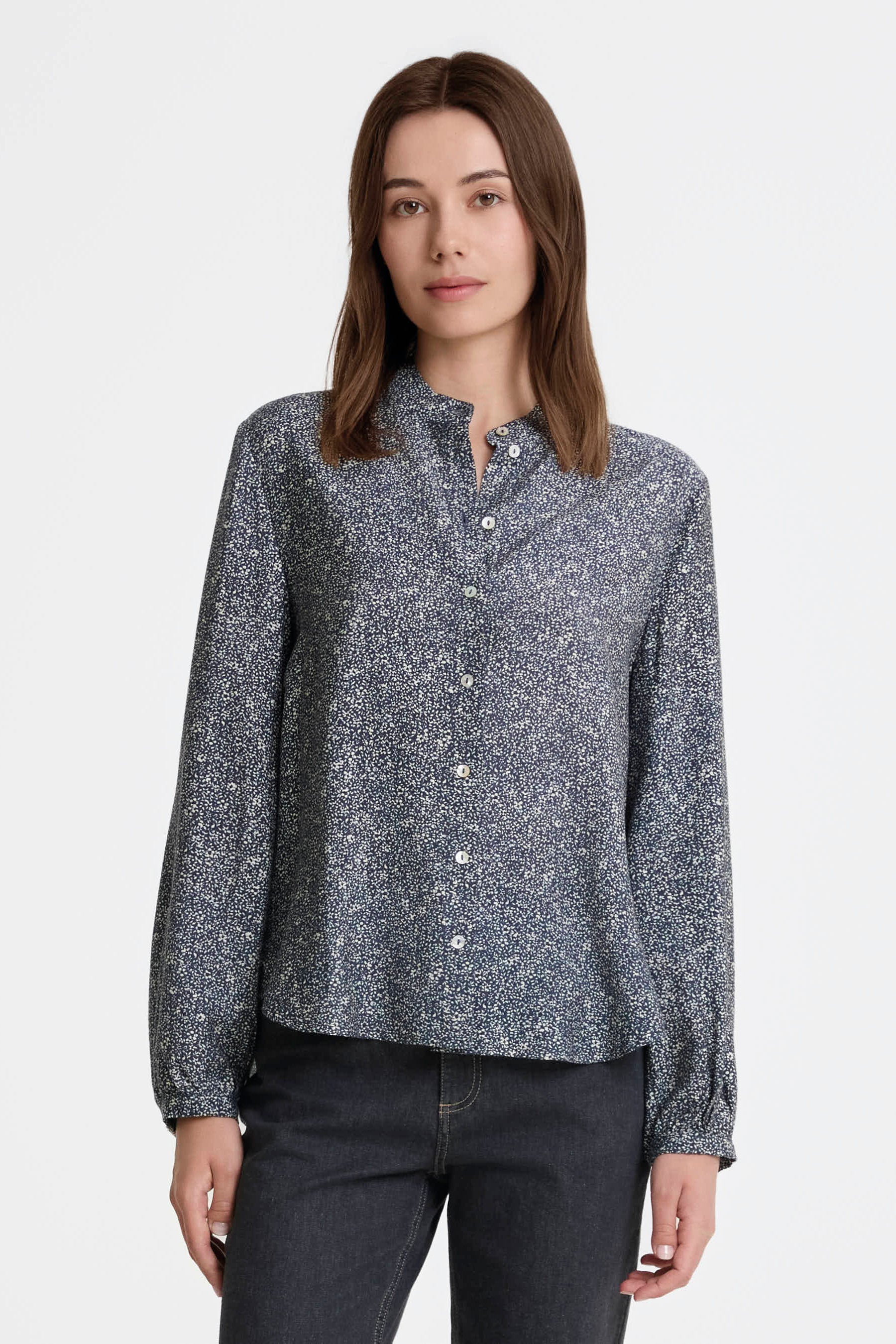 Woman wearing a patterned shirt on a white background