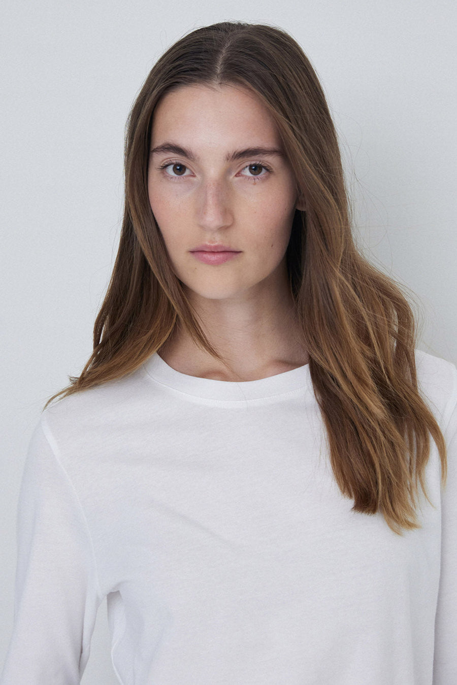 Round neck long sleeve tee shirt in white close up. 