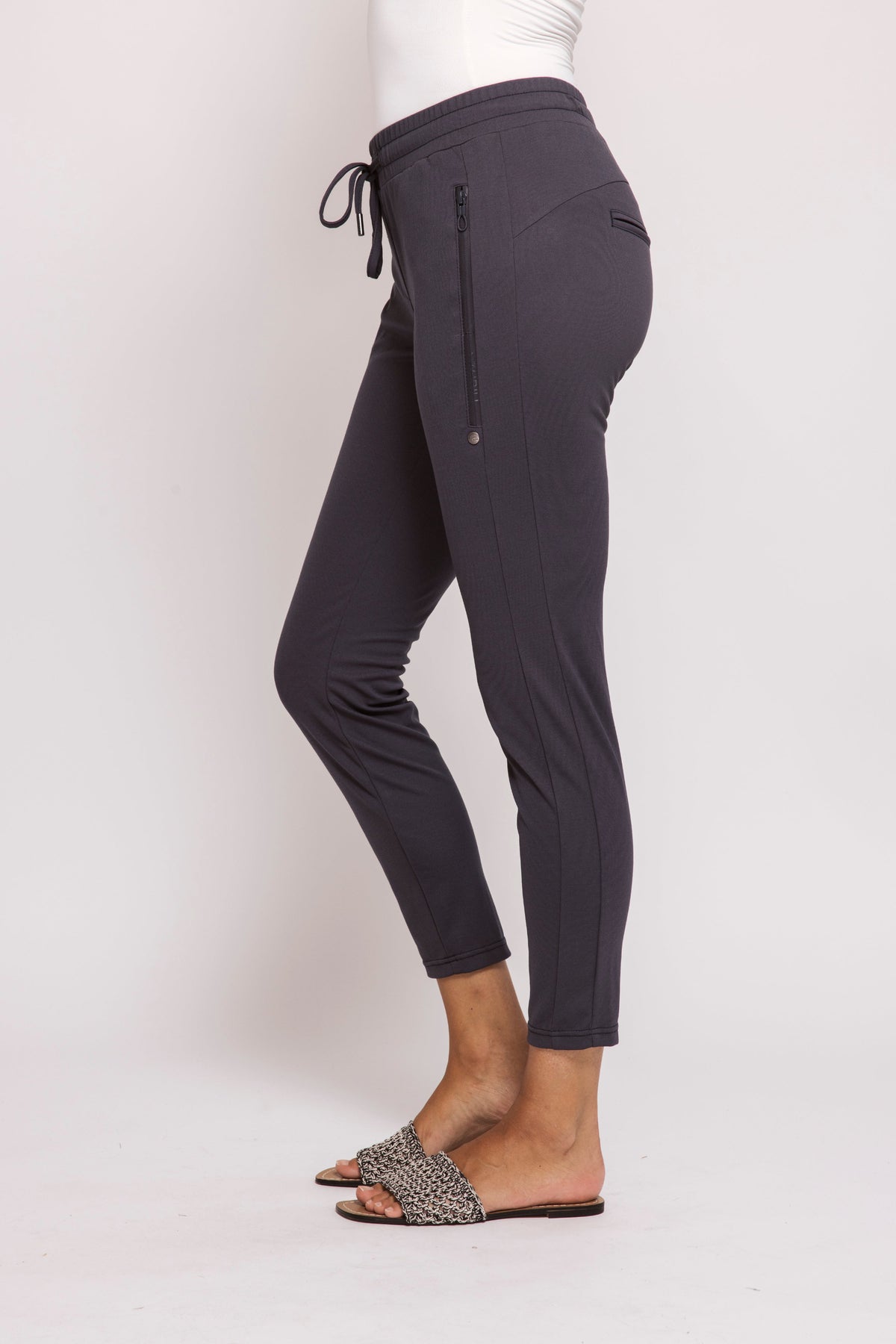 Dark gray jogger pants worn by a person on a white background