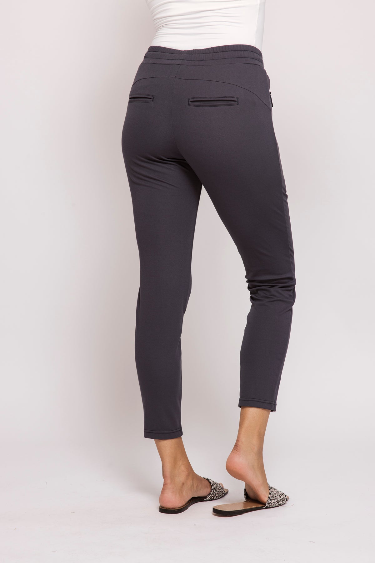 Blue slim fit pants worn by a person on a white background