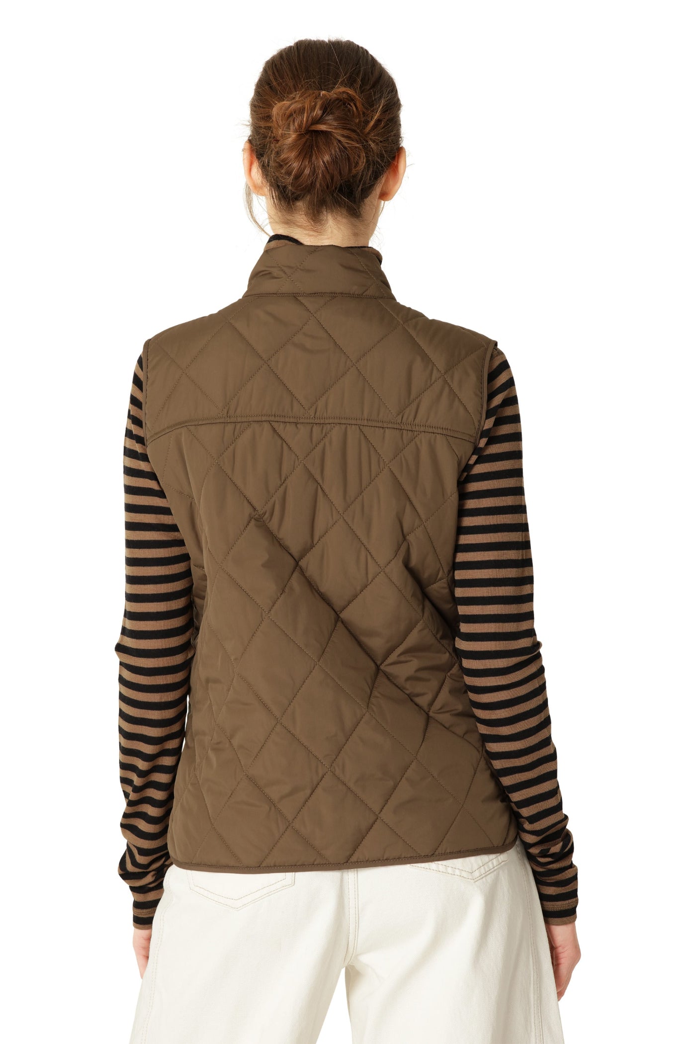Person wearing a brown quilted vest over a striped shirt on a white background