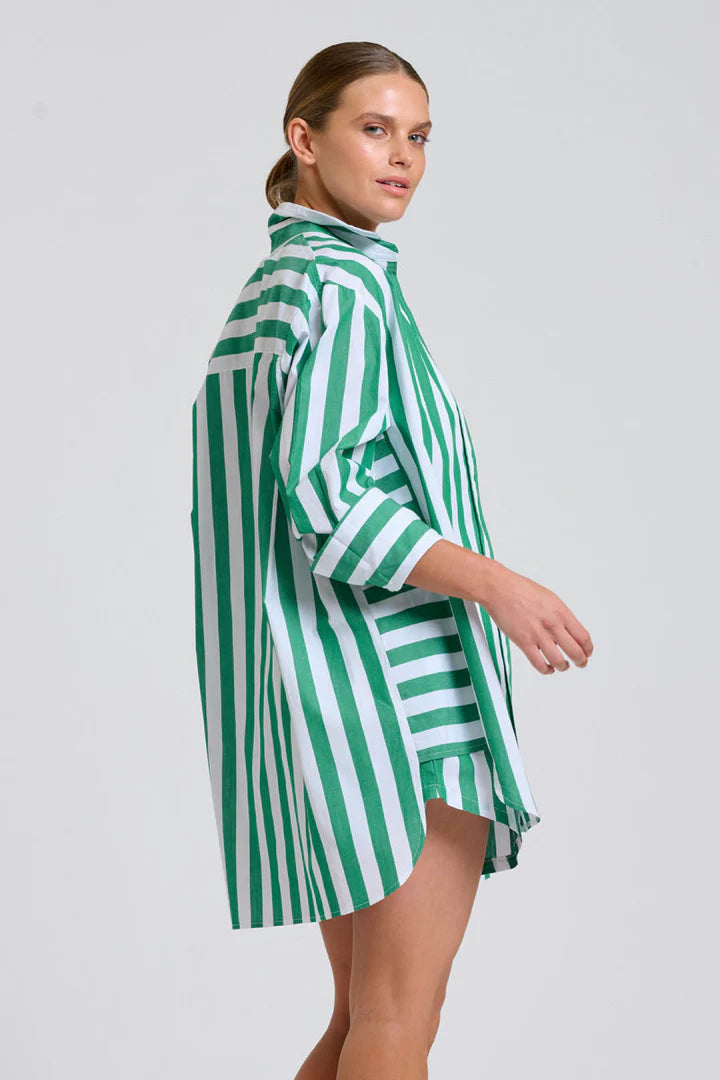Woman wearing a green and white striped dress on a plain background